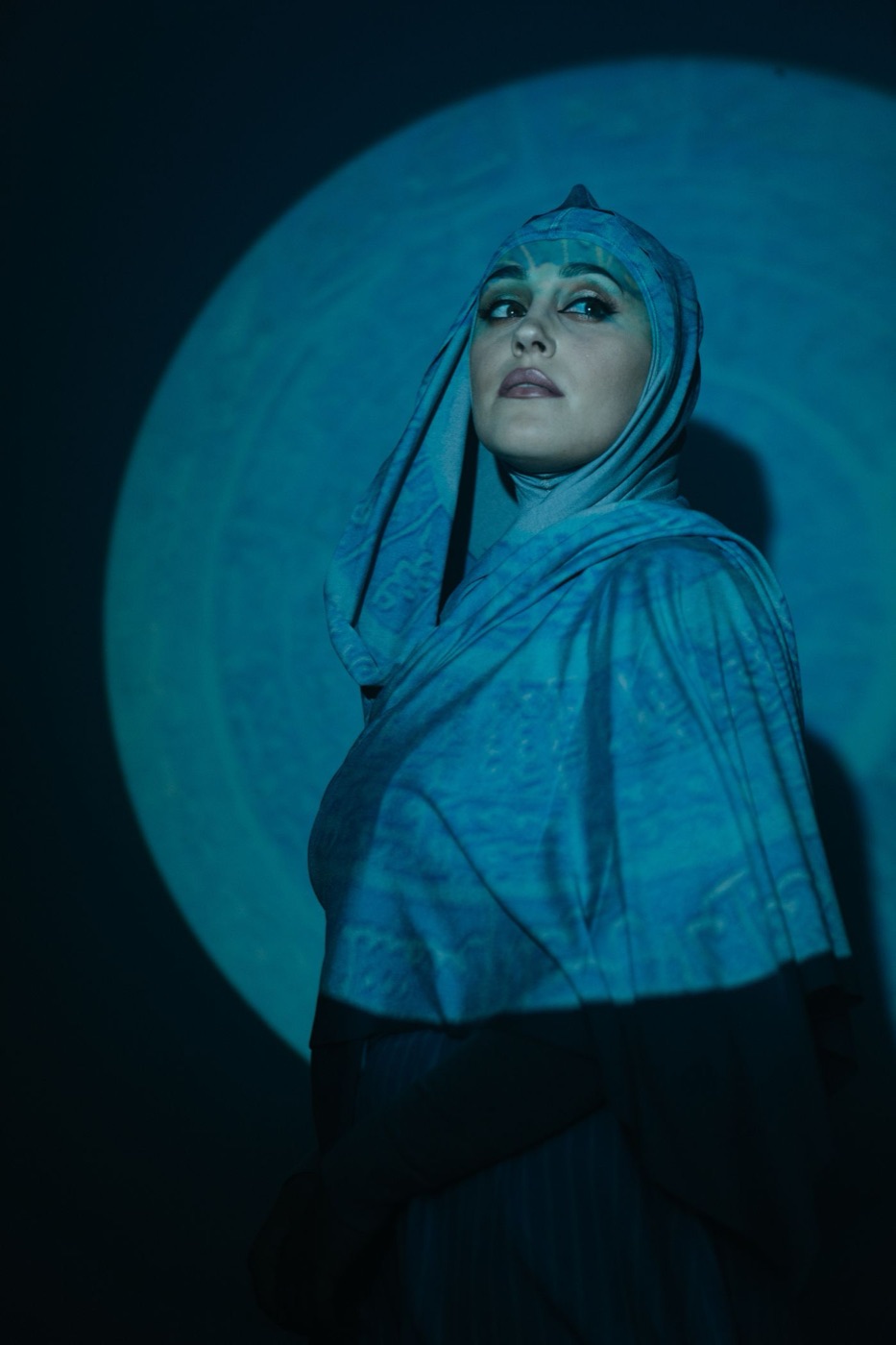 Portrait of a woman in a blue hijab under blue light